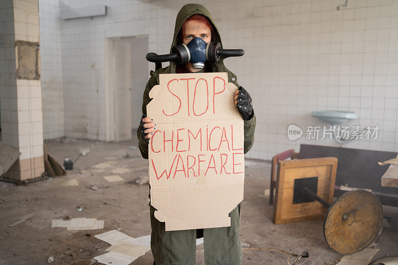 一名女军人戴着防毒面具，横幅上写着“停止化学战、世界末日、核武器、核电站的原子爆炸、保护化学武器和核武器”。戴面具的女孩
