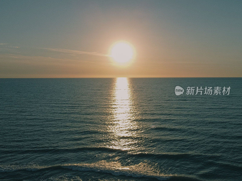 太阳从海面或海洋上升起，在水中反射太阳的景象
