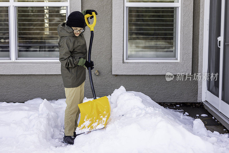 男孩在家里铲雪