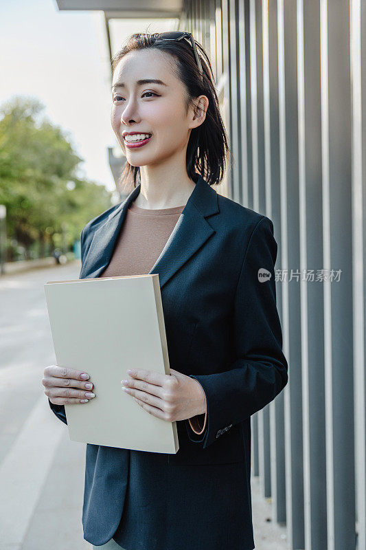 成功的女经理站在城市的大街上。