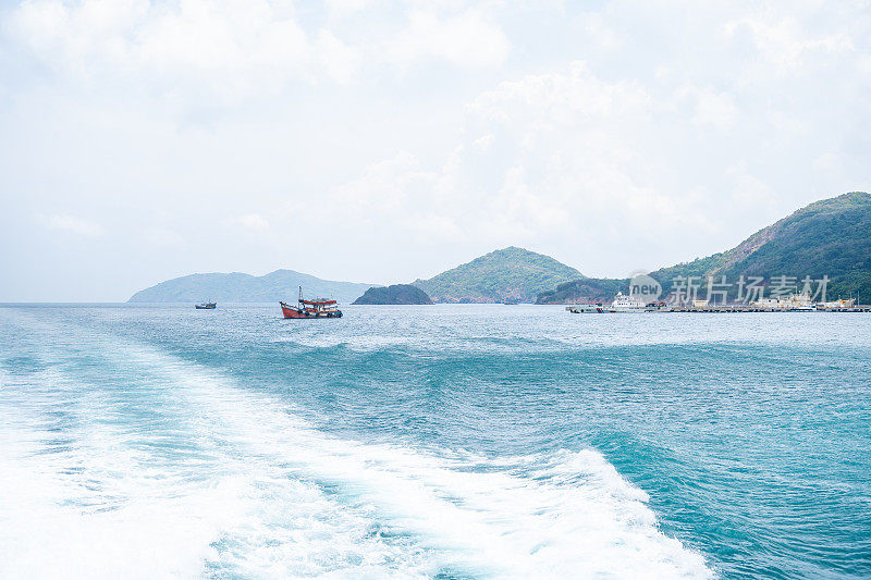 越南孔岛的本坝港，有美丽的碧海蓝天山和五颜六色的小船。