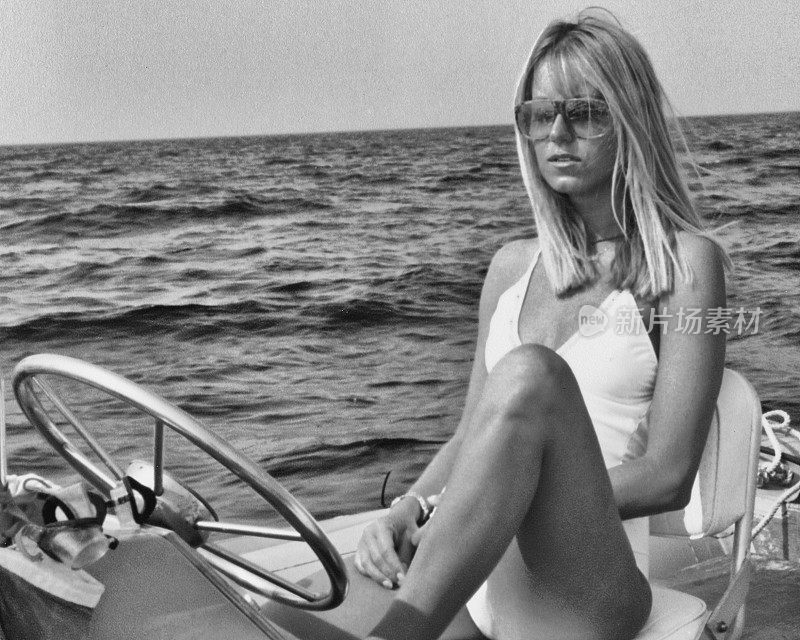 1968年，一名穿着泳装的年轻女子坐在充气木筏上。