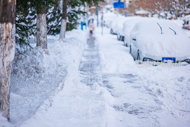 被大雪困住的汽车一动不动地停在房子院子里的雪地里