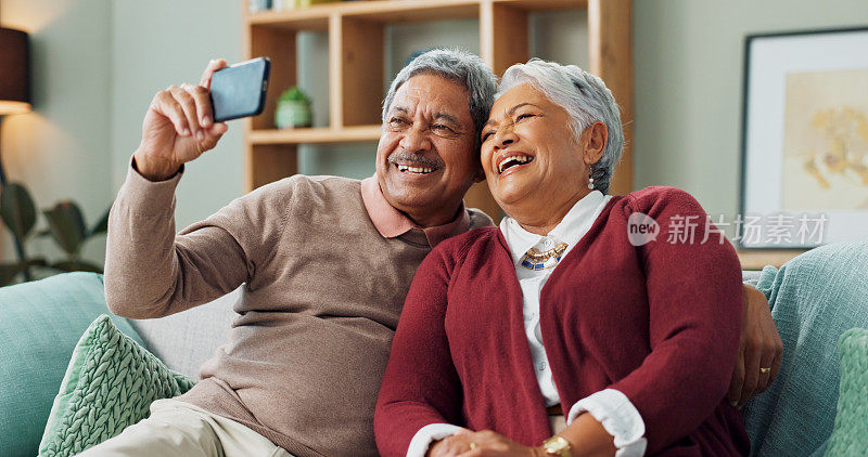 老夫妇，笑声和智能手机在客厅视频通话，联系和沟通。人们，成熟的男人和女人坐在沙发上，自拍和房子一起用手机上网聊天