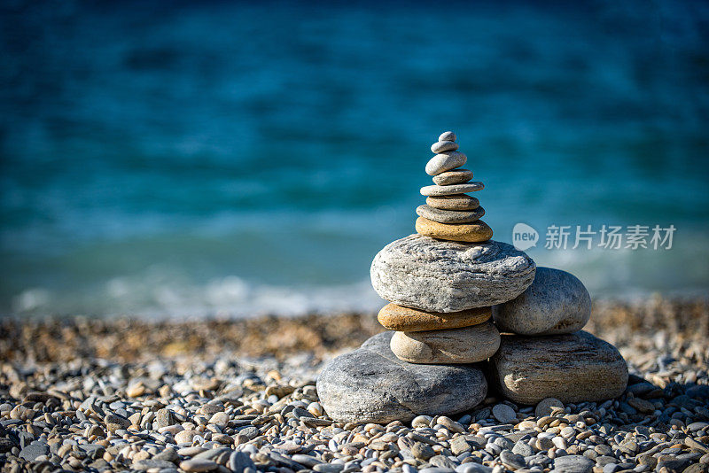 在布满鹅卵石的海边，把石头堆在一起保持平衡