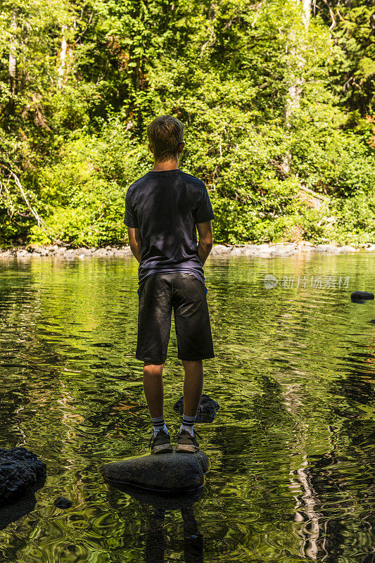 一个少年在加拿大不列颠哥伦比亚省徒步旅行时，在一个美丽的湖边