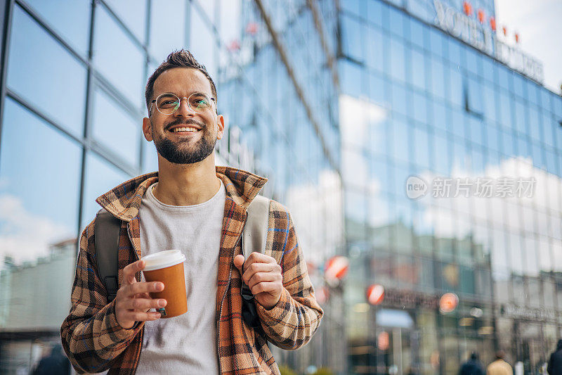 下班后，一个面带微笑的成年男子走出办公楼。