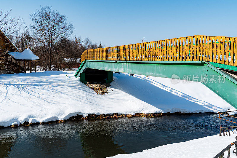 绿黄相间的小桥横跨雪水，与自然景观融为一体