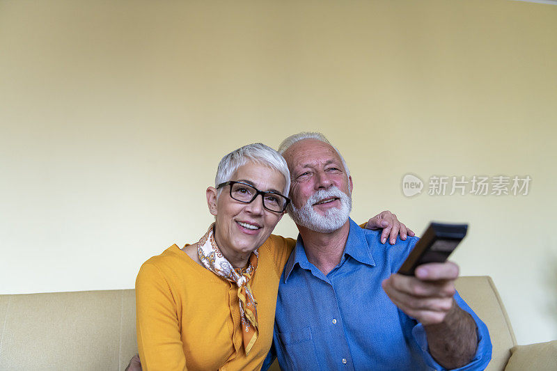 一对大四的夫妇正在家里享受他们最喜欢的电视节目。