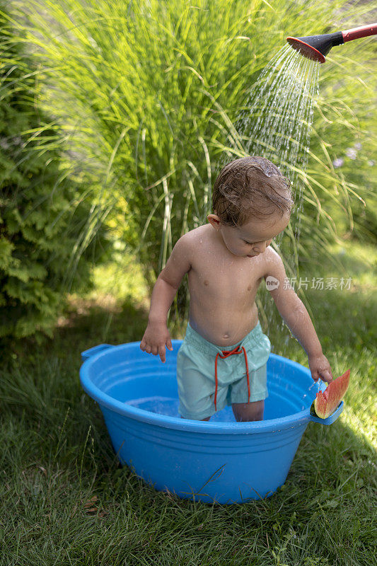 巴拿马的一个小男孩在院子里洗澡