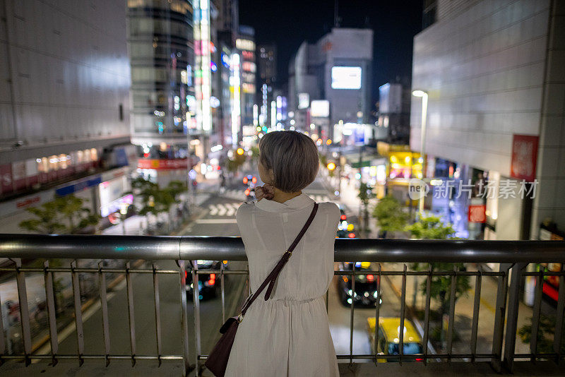 年轻女子从脚灯看夜景