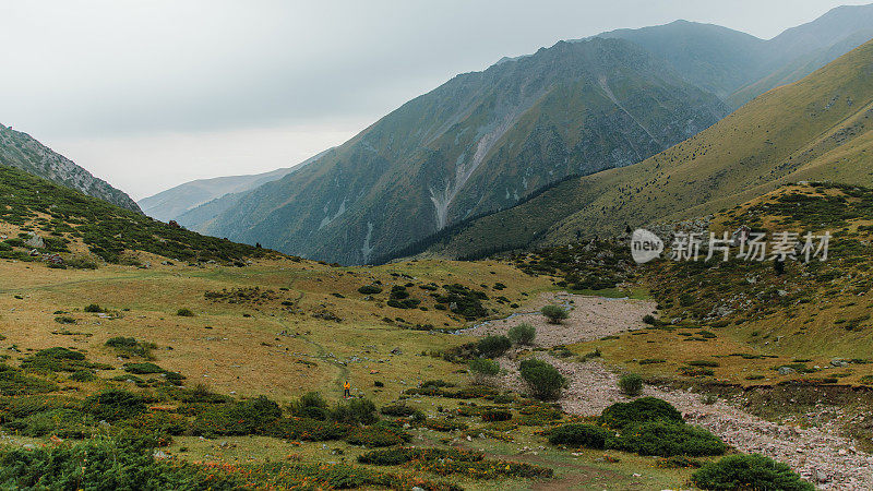 一名背包客在夏天的中亚山区徒步旅行