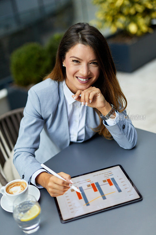 成功的女商人在cafè使用数码平板电脑工作的肖像