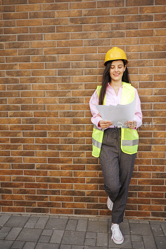 女施工经理站在黄色安全背心和黄色安全帽的肖像