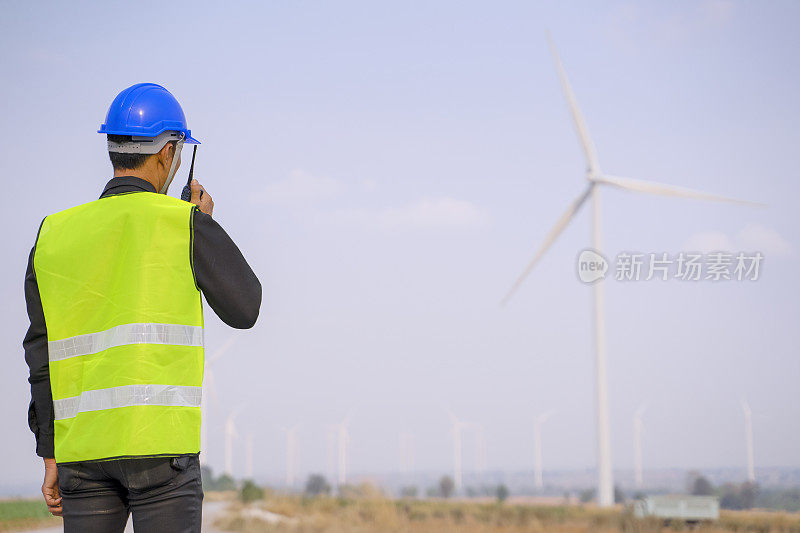 电力工地的蓝领工人。风车。