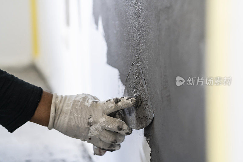 人类的双手在混凝土墙壁纹理上工作的特写