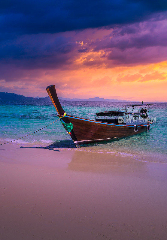 泰国甲米的Railay海滩上壮观的日落，前景是传统的长尾船