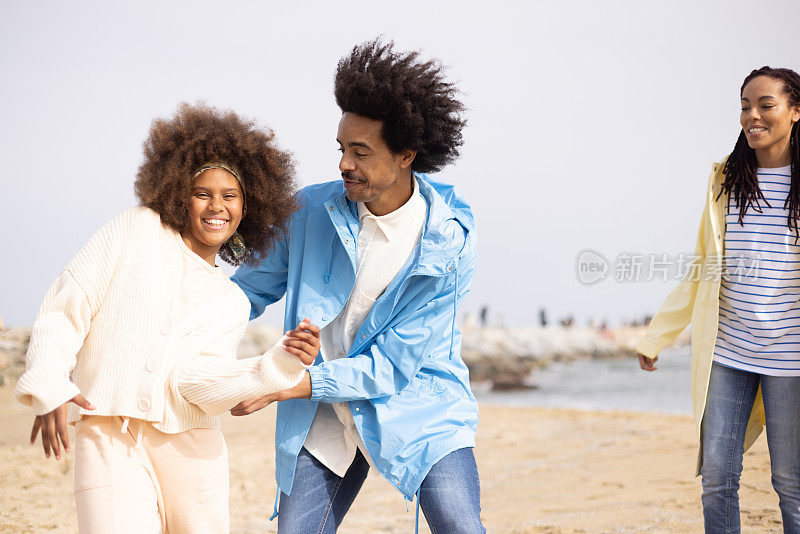 非洲裔女孩和她的父母在海滩上玩得很开心
