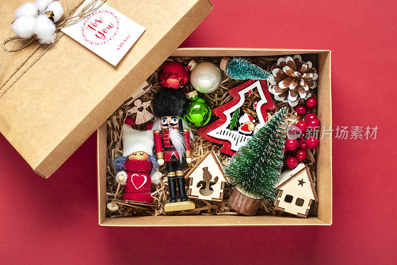 手工关怀包，季节性的礼品盒玩具，圣诞装饰在红色的桌子上，个性化的环保篮子，为家人，朋友，女孩为12月24日，圣诞节，新年的一天平躺