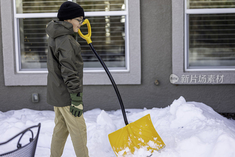 男孩在家里铲雪