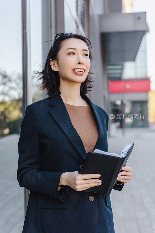 成功的女经理走在城市的街道上。