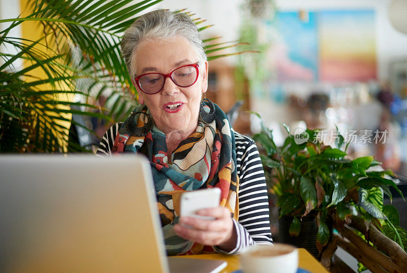 咖啡馆，笔记本电脑和高级女性，在放松时用手机发短信，上网或搜索，咖啡和远程工作。自由职业者，成熟的女士，在咖啡店使用应用程序，社交媒体或在线计划