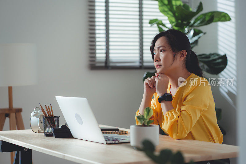 结婚后，坐在家里办公室的亚洲女性感到很难过。