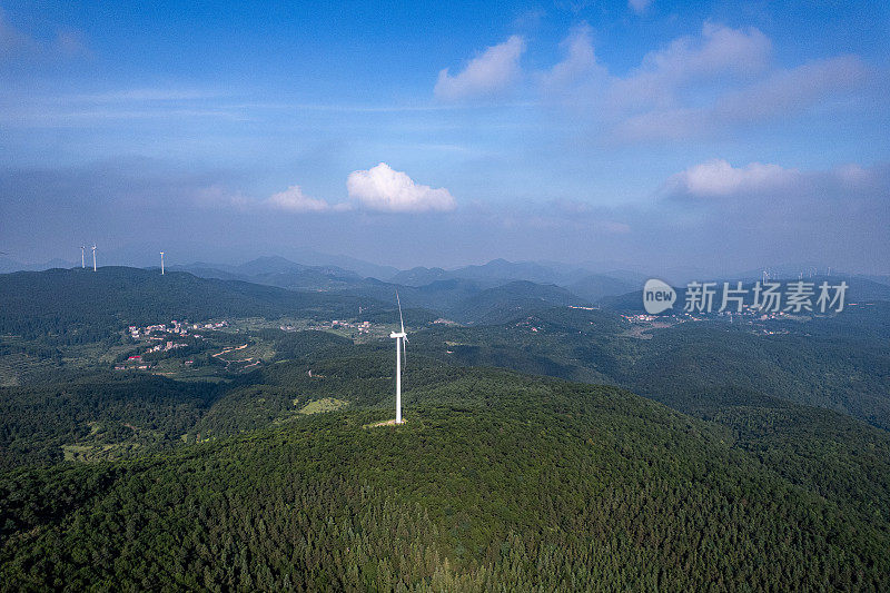 在阳光明媚的日子里，森林山上的风力涡轮机