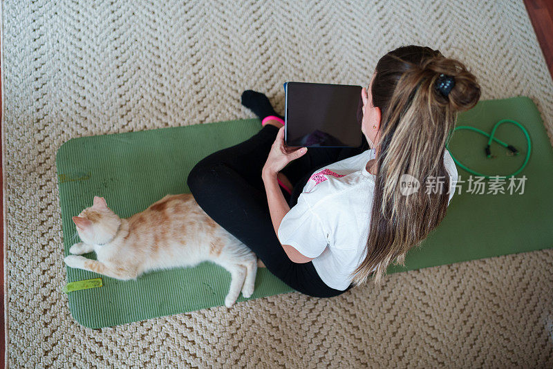 孕妇在家锻炼和使用平板电脑