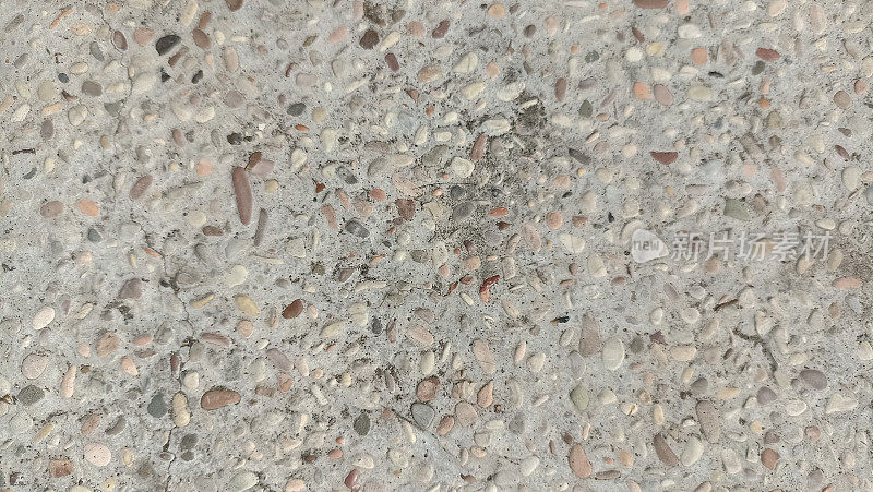 带有彩色砾石夹杂物的混凝土表面(墙)。磨碎的混凝土纹理与暴露的鹅卵石。带有花岗岩砾石内含物的混凝土未经抛光的表面图案。