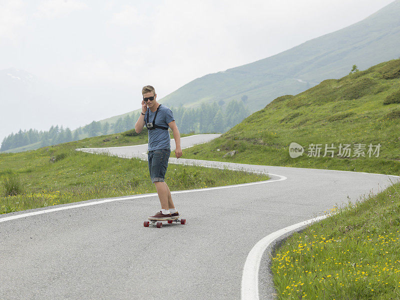 年轻人沿着山路长板而下