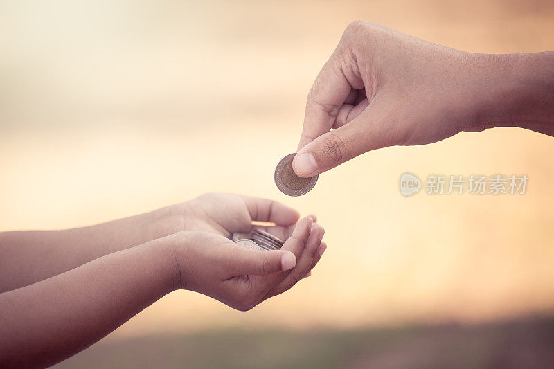 母亲给孩子硬币是省钱的理念