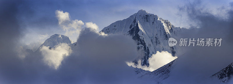 云朵绕着尼泊尔喜马拉雅山雪山的高海拔山峰盘旋