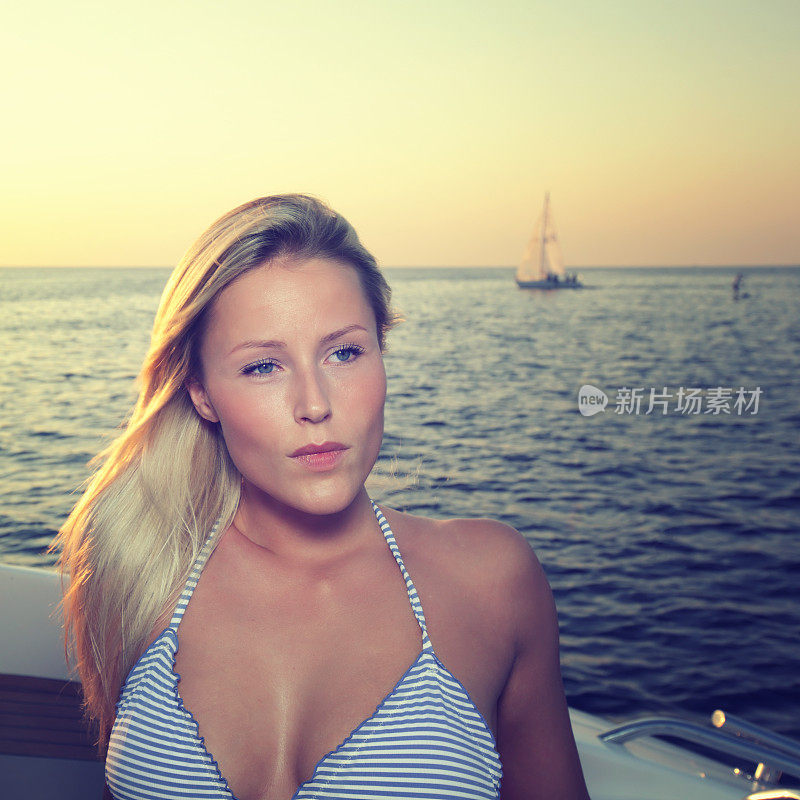 厄勒海峡黄昏时，性感女孩坐在游艇上