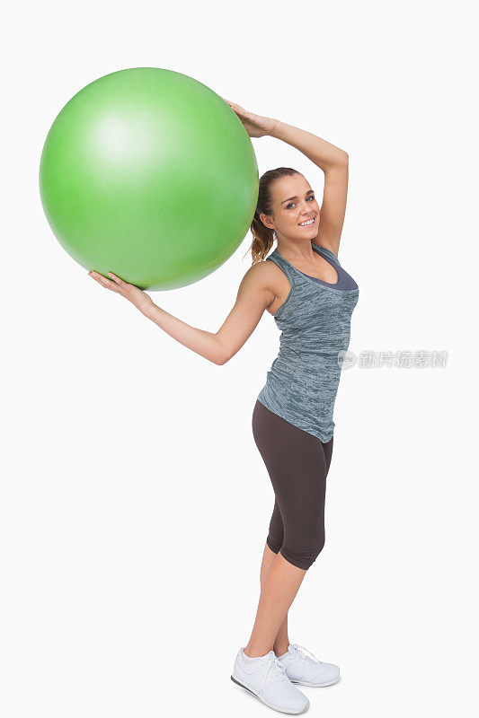 快乐的金发女人拿着健身球