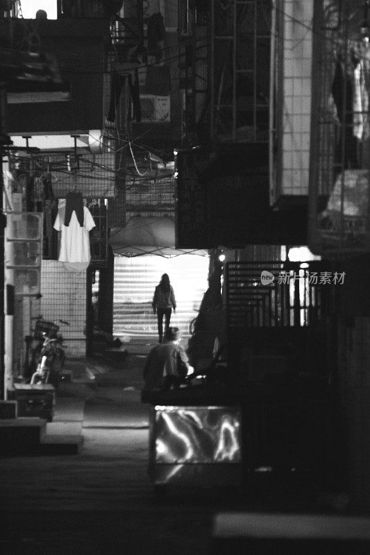 中国珠海，人们走在黑暗的小巷里