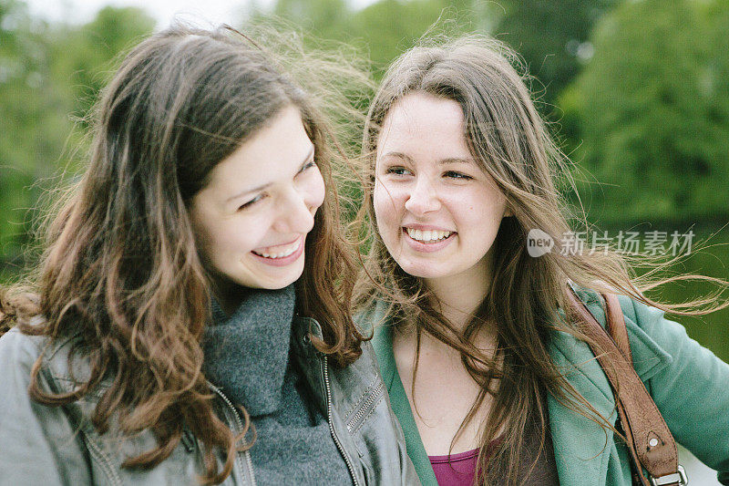 友谊:两个欢笑的年轻女人在户外一起玩乐