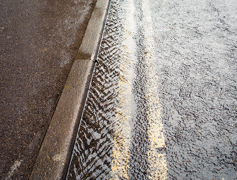 雨水顺着街道排水沟流淌