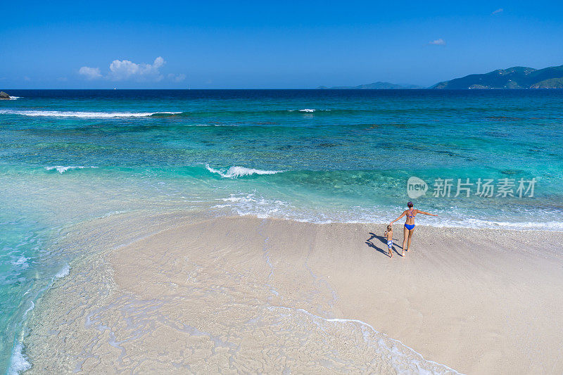 妈妈和孩子在热带海滩上玩耍