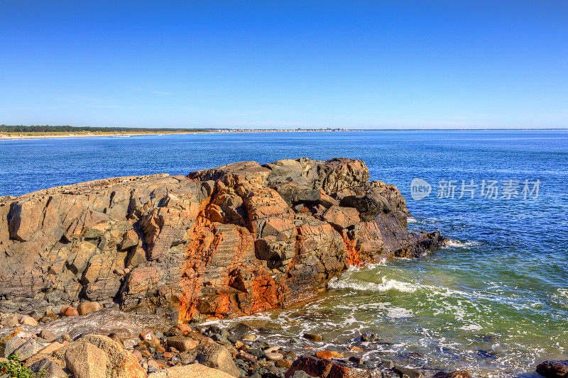 缅因州Ogunquit的岩石和海洋冲浪。蓝色的天空。