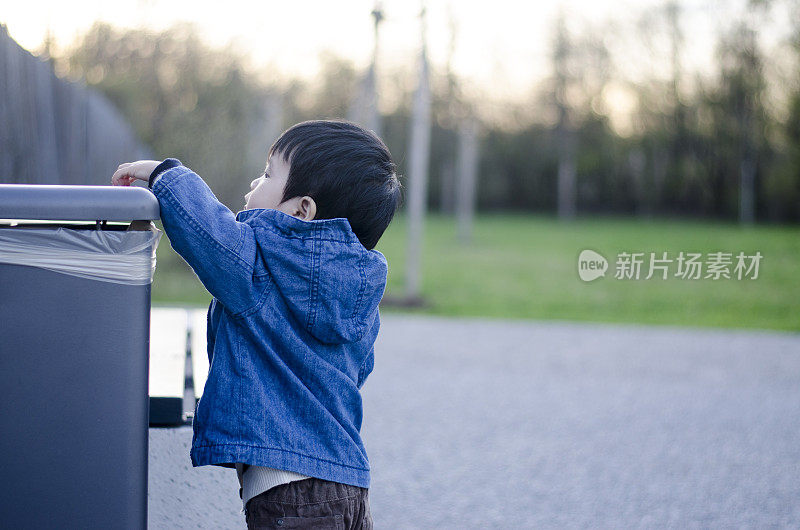 亚洲小孩和垃圾桶