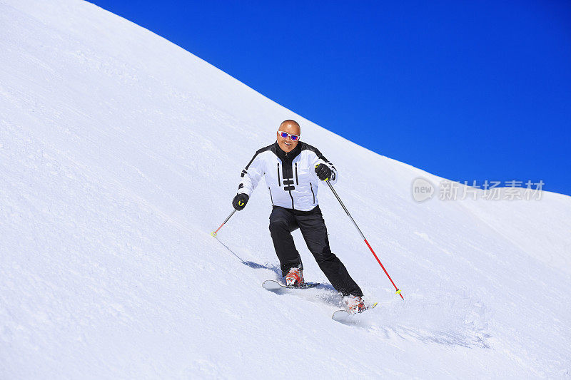 成熟的男人在阳光明媚的滑雪场滑雪