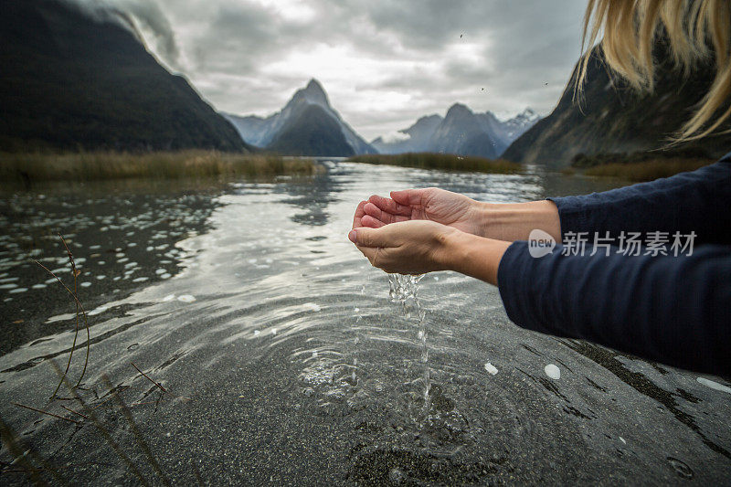 新西兰，人们用手从湖中舀取淡水