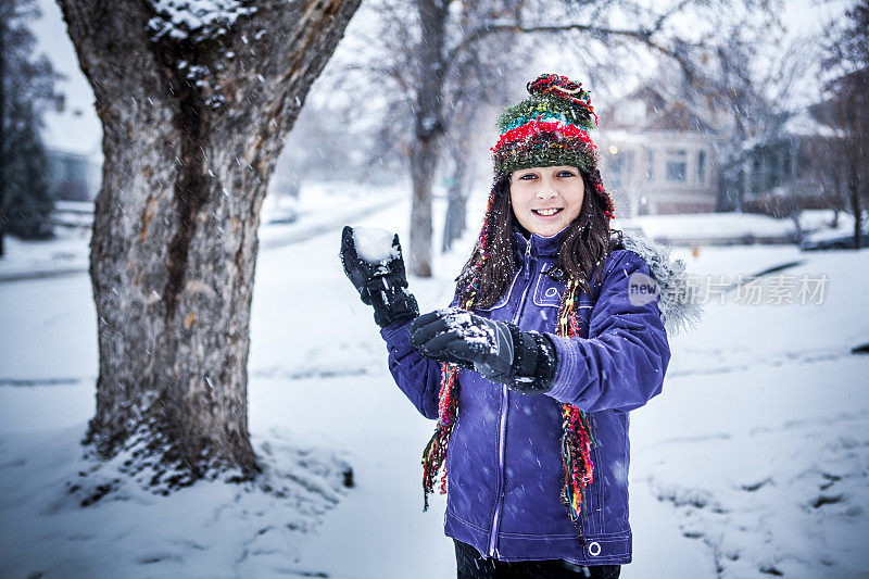 可爱的小女孩在冬天扔雪球