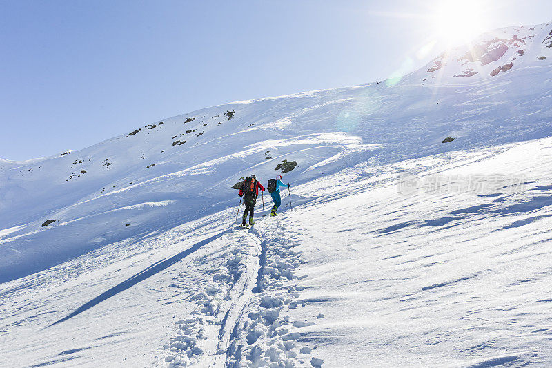 一对高山滑雪夫妇登上山顶