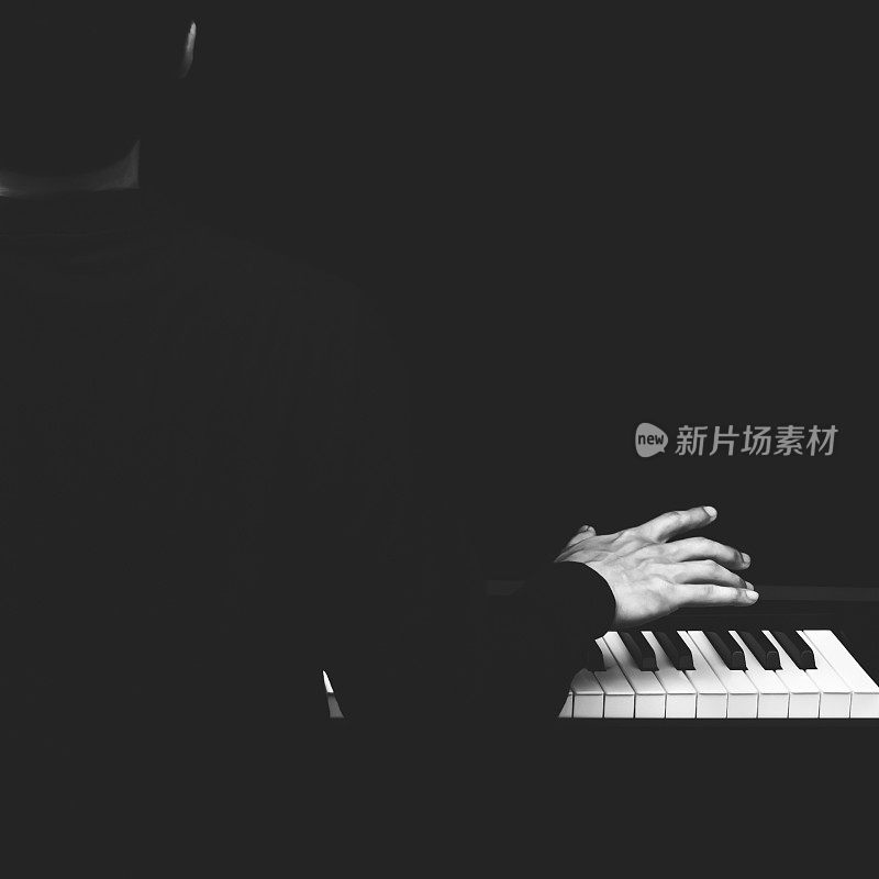 背部的男性亚洲音乐家弹钢琴