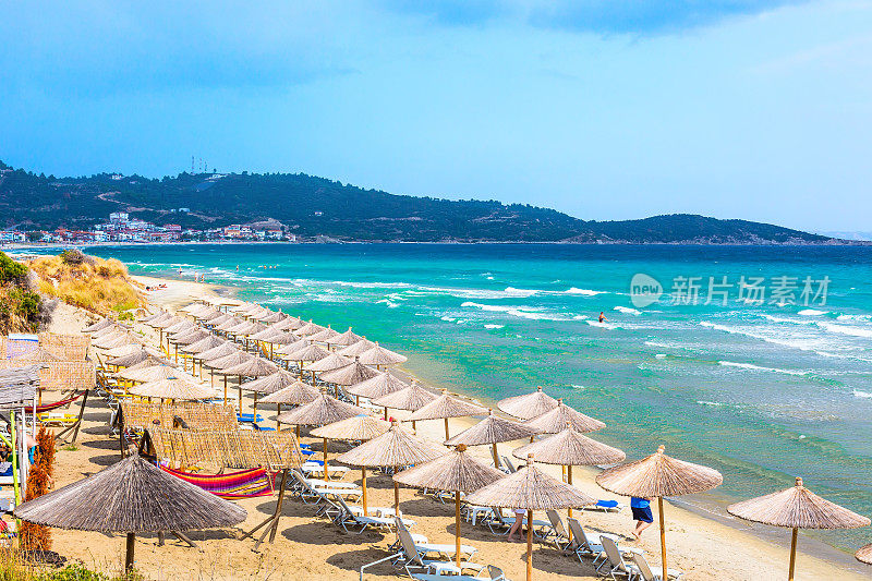 海滩背景与绿松石海浪和雨伞，希腊