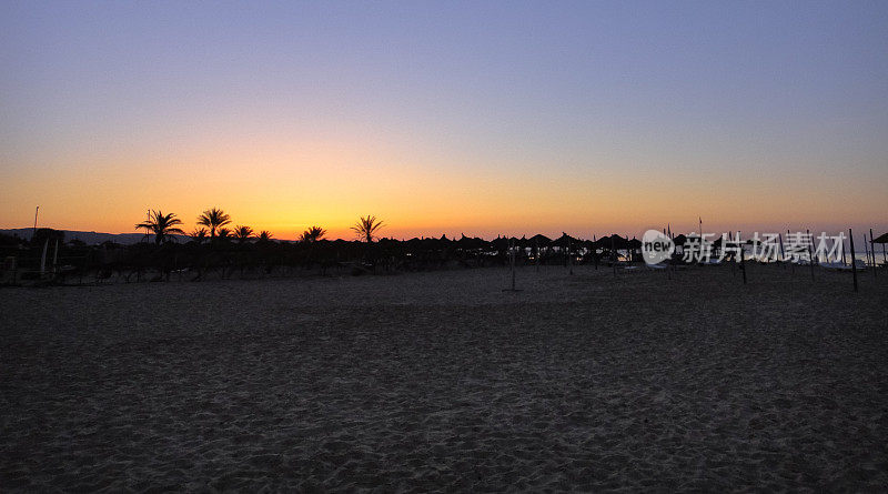 美丽的日落在突尼斯哈马迈特镇附近的海滩上。地中海。北非