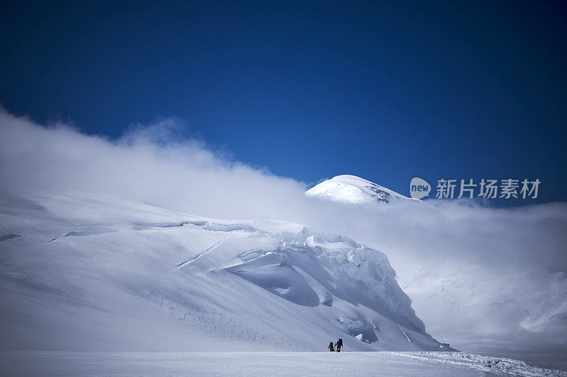 徒步旅行者用雪橇在西扶壁路线的冰川上攀登德纳里。