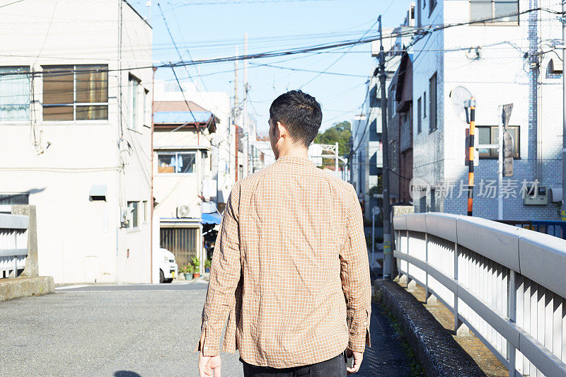 一个日本年轻人在邻居周围散步